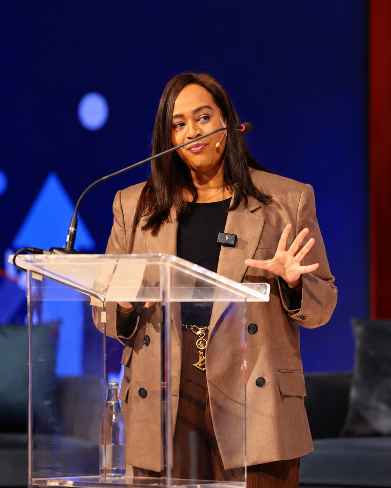 Desh speaking on stage, mid-conversation at the podium